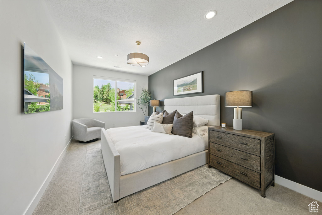 Bedroom featuring light carpet, baseboards, recessed lighting, and a textured ceiling