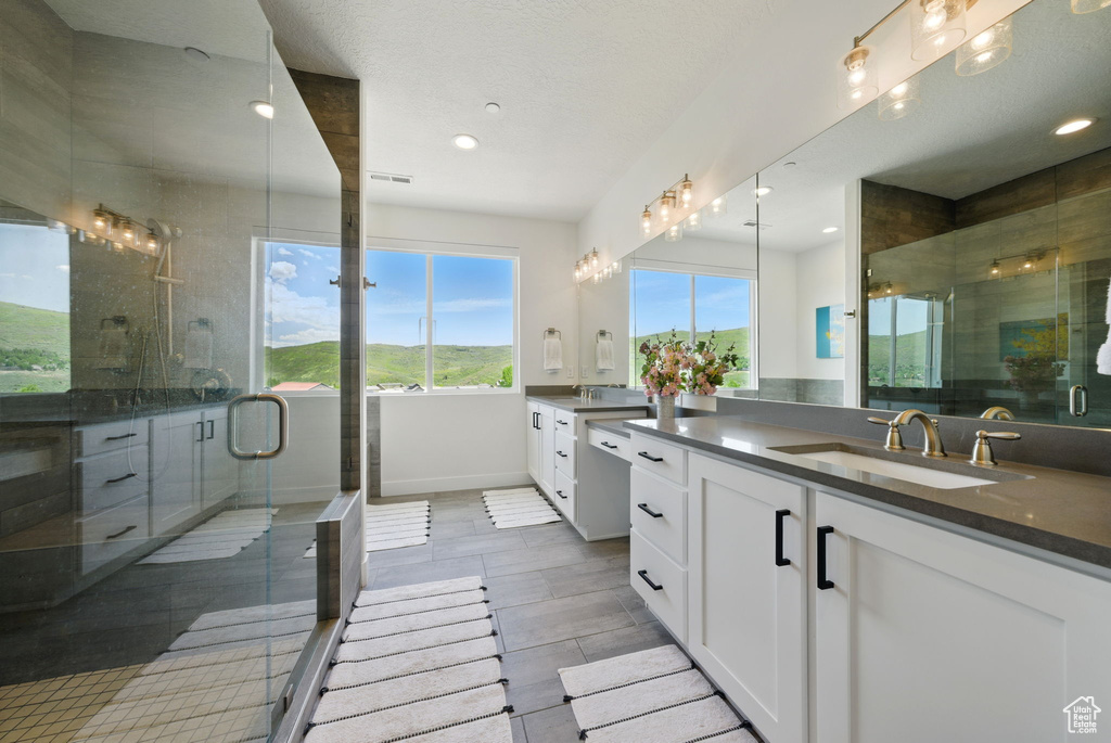 Bathroom with vanity, a stall shower, recessed lighting, and baseboards