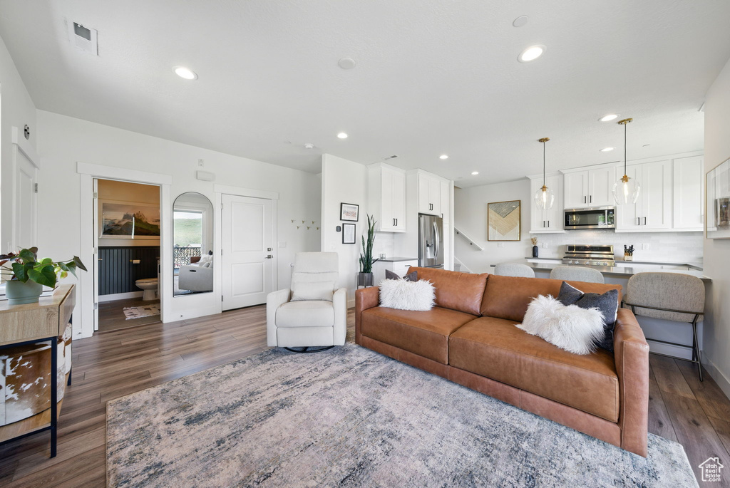 Living room featuring dark wood finished floors, recessed lighting, baseboards, and stairway
