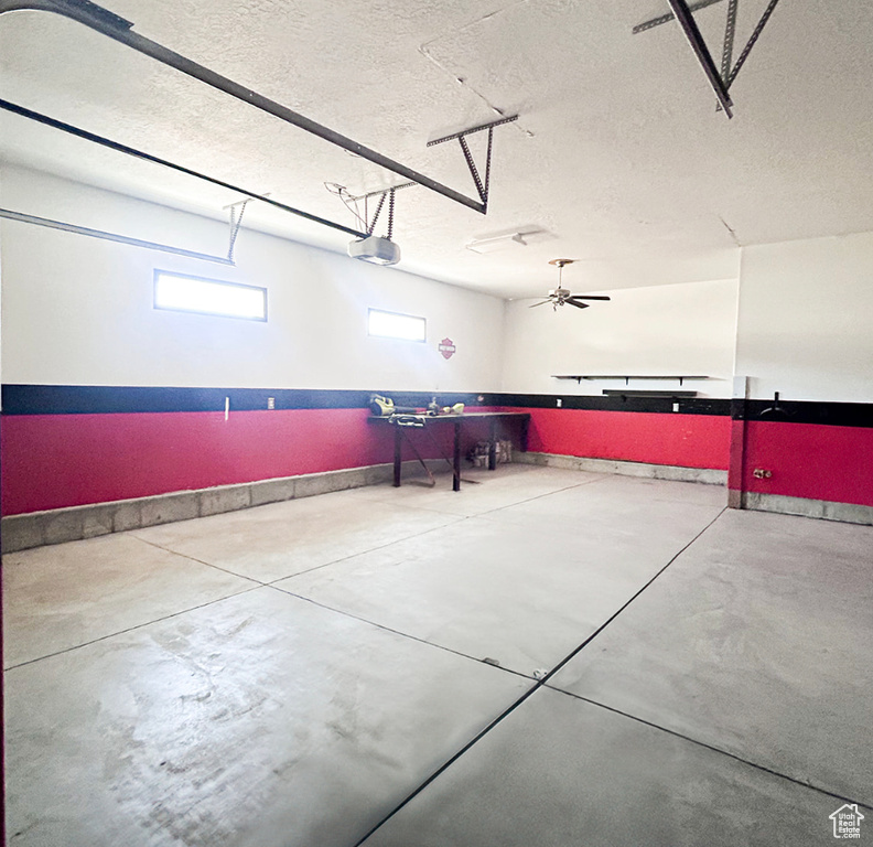 Garage with baseboards and a garage door opener