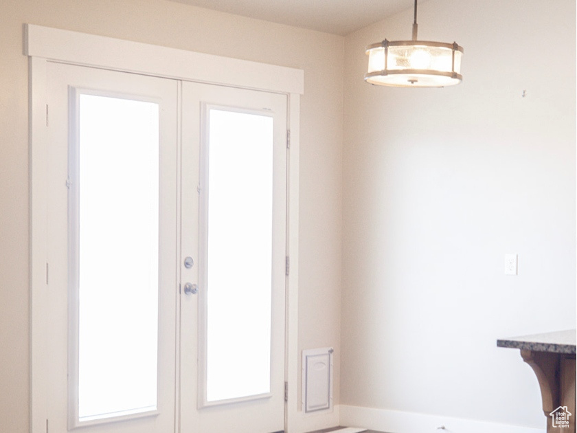 Doorway to outside with french doors, wood finished floors, and baseboards