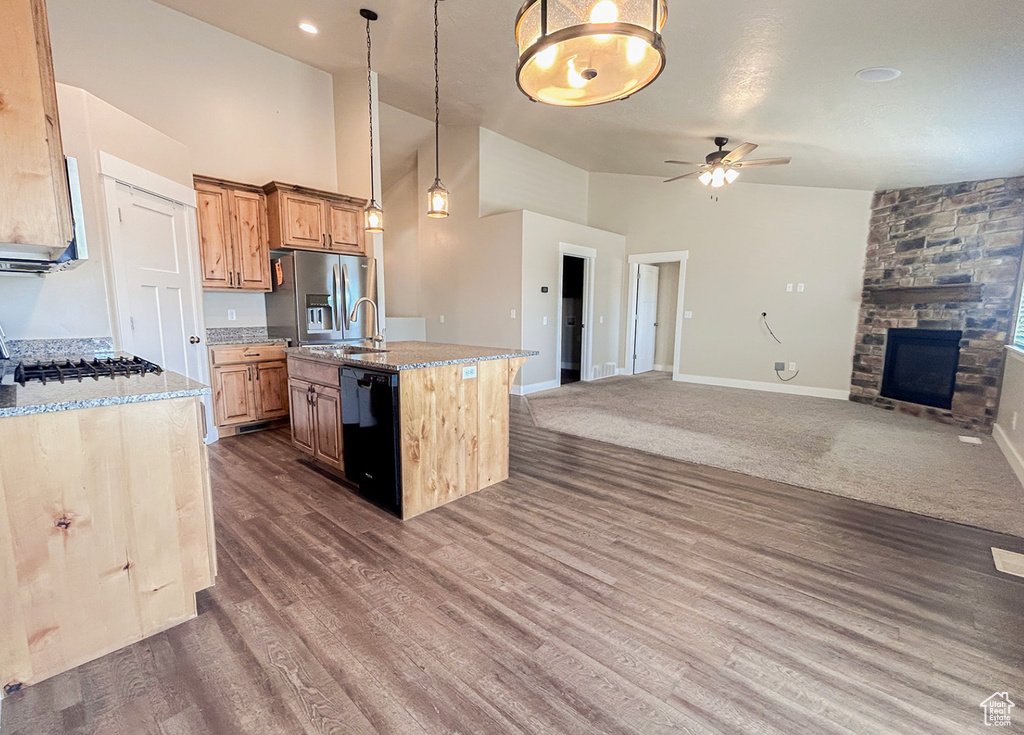 Kitchen featuring dishwasher, open floor plan, ceiling fan, stainless steel fridge with ice dispenser, and high vaulted ceiling