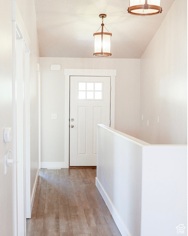 Doorway to outside with light wood-style flooring and baseboards