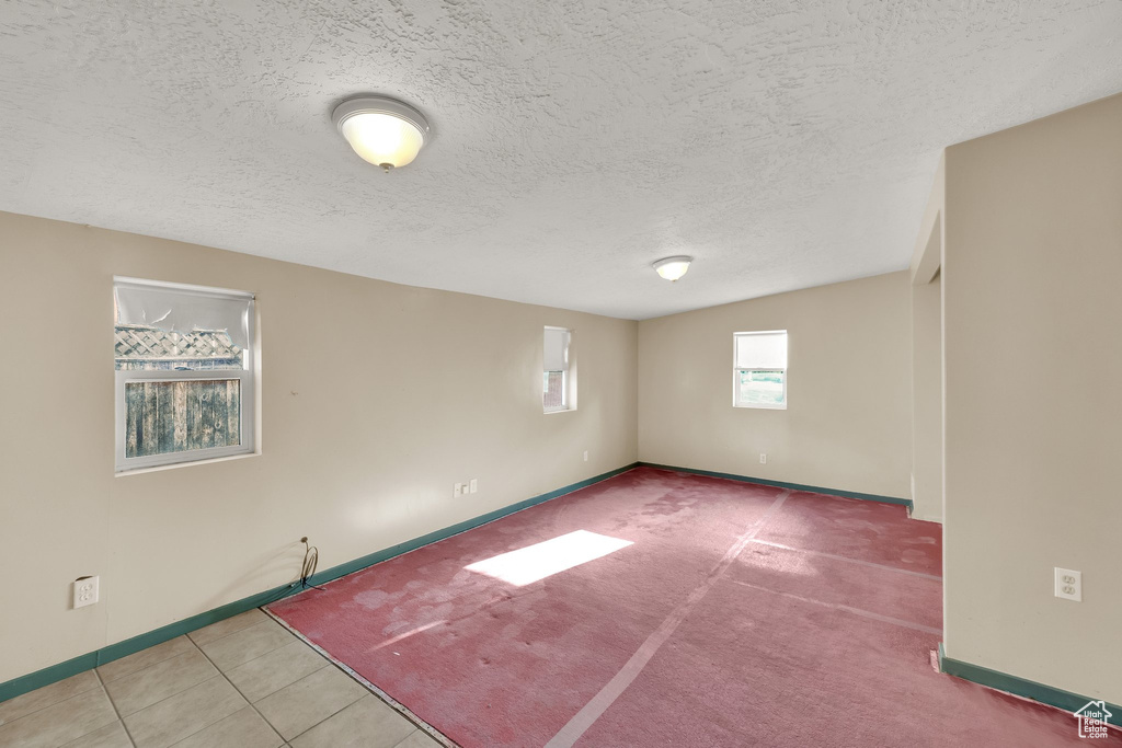 Unfurnished room featuring baseboards and a textured ceiling