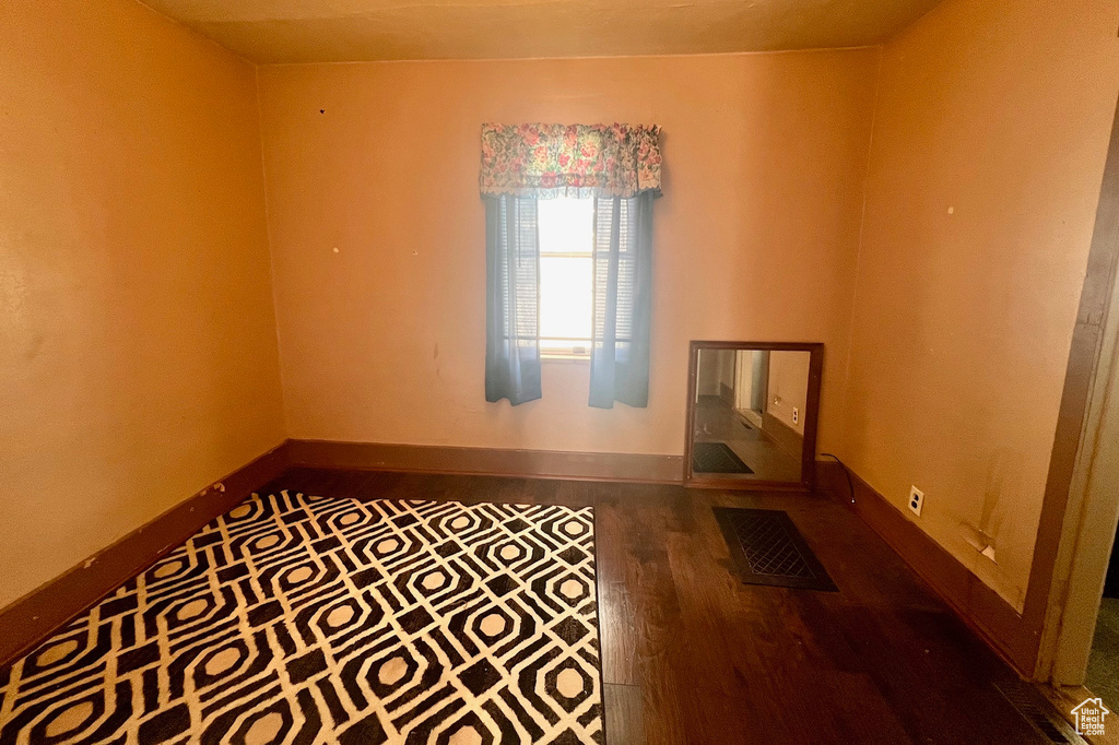 Unfurnished room with wood finished floors and baseboards