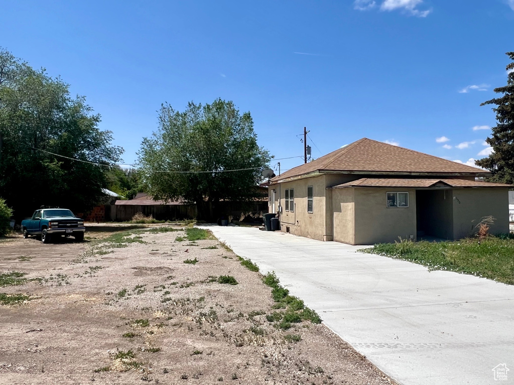View of property exterior with driveway and stucco siding