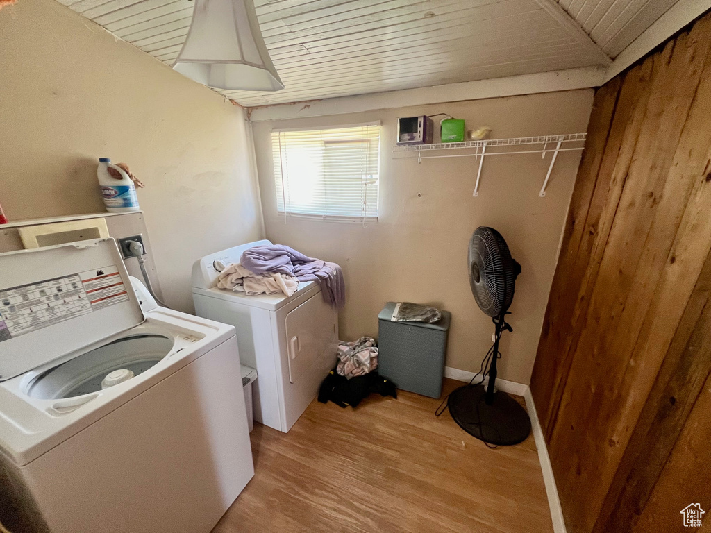 Laundry area featuring independent washer and dryer, light wood finished floors, and wooden ceiling