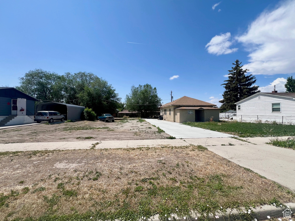 View of front facade featuring a detached carport and driveway