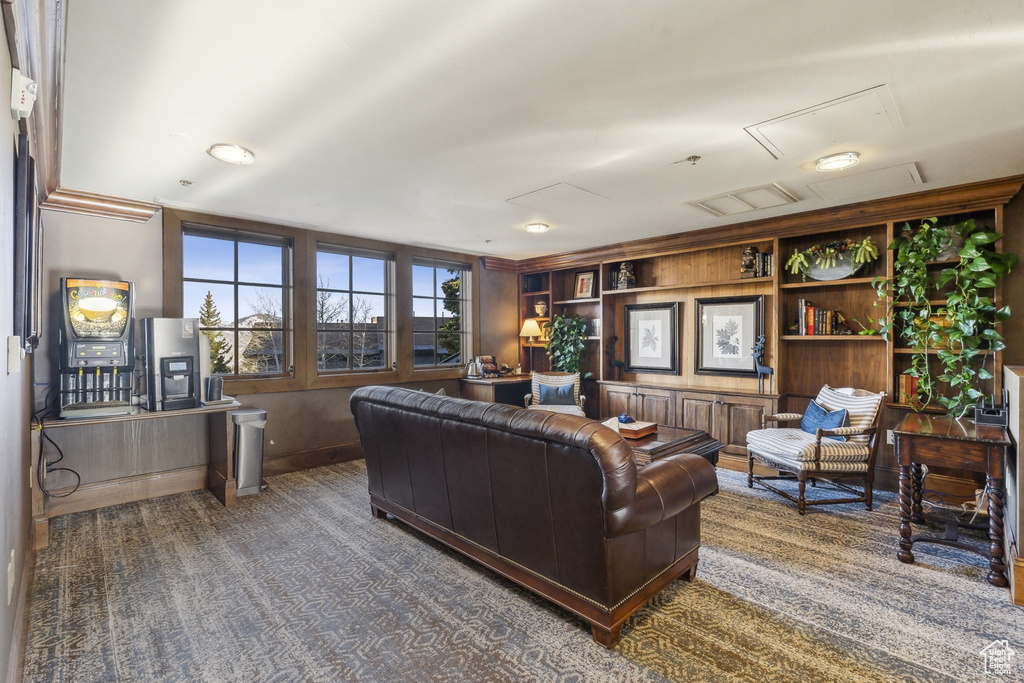Living room with carpet floors, built in features, attic access, and baseboards