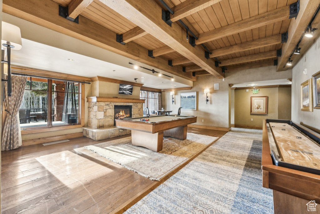 Playroom with wood ceiling with exposed beams, a fireplace, light wood-type flooring, pool table, and baseboards