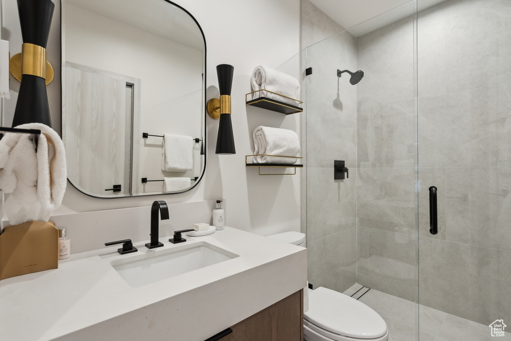 Full bath featuring a shower stall, toilet, and vanity