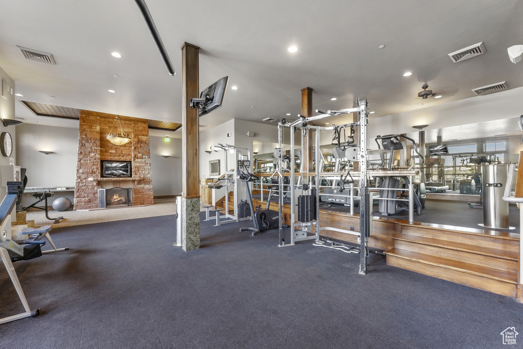 Gym featuring a stone fireplace and recessed lighting