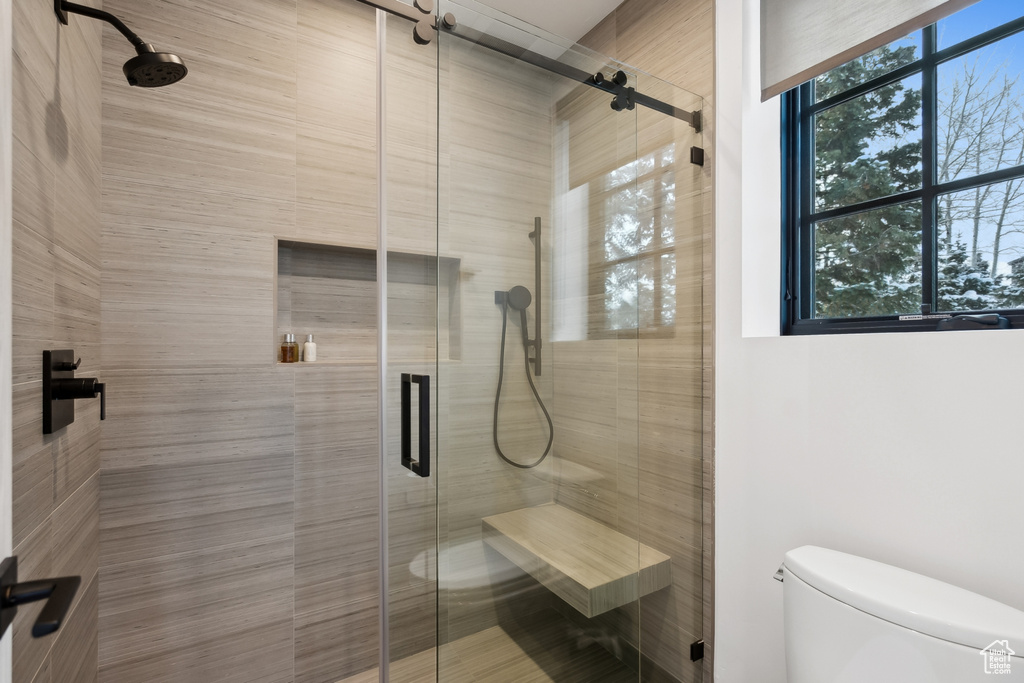 Bathroom featuring toilet and a shower stall