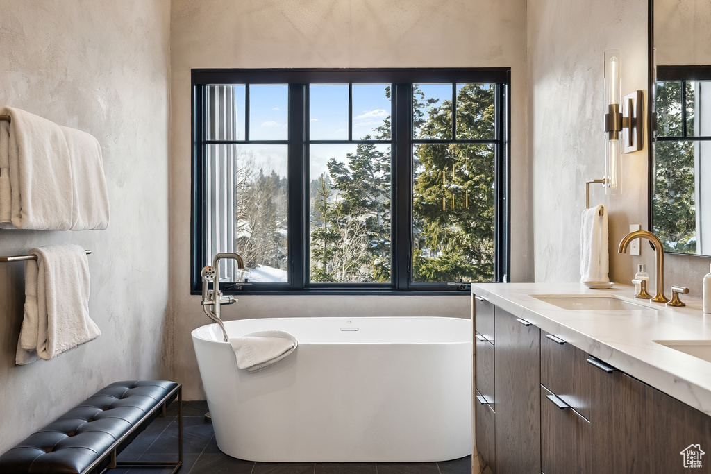 Full bathroom with a soaking tub, double vanity, and tile patterned floors