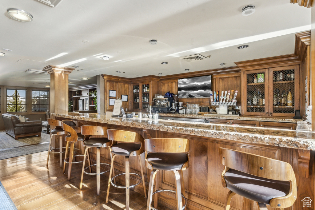 Community bar area featuring ornate columns and wood finished floors