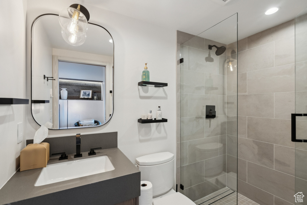 Bathroom featuring toilet, walk in shower, vanity, and recessed lighting
