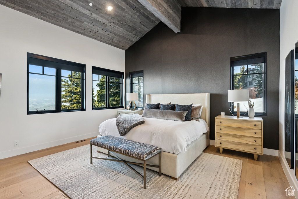 Bedroom with high vaulted ceiling, light wood finished floors, multiple windows, baseboards, and recessed lighting