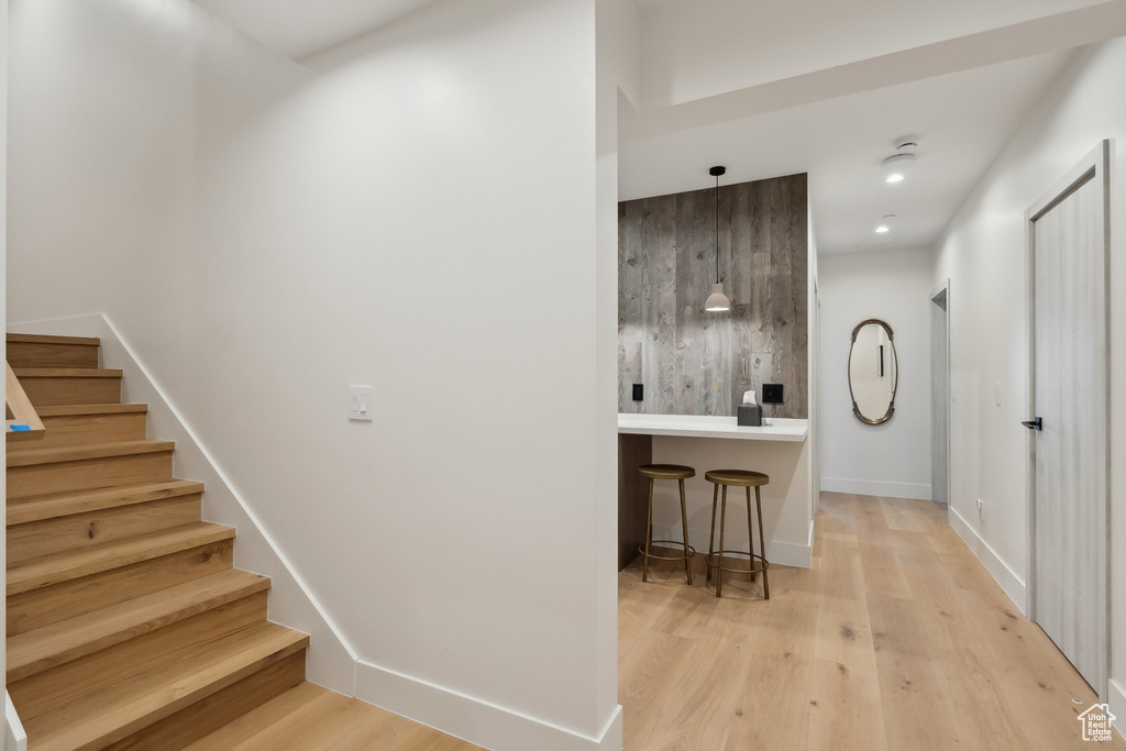 Stairway with wood finished floors and baseboards