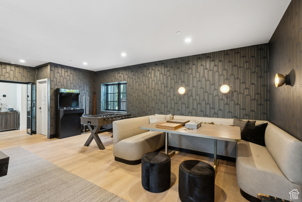 Living room with light wood-style flooring, wallpapered walls, and recessed lighting