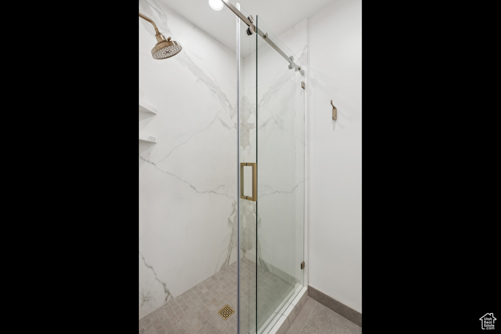 Full bath with a marble finish shower