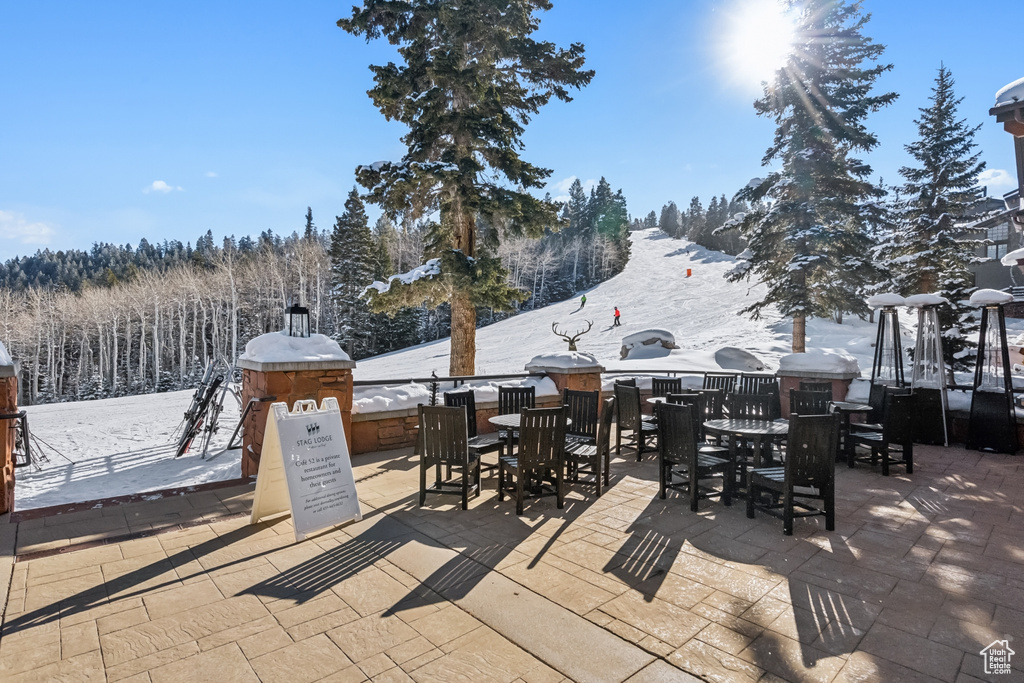 Snow covered patio with outdoor dining area and a patio