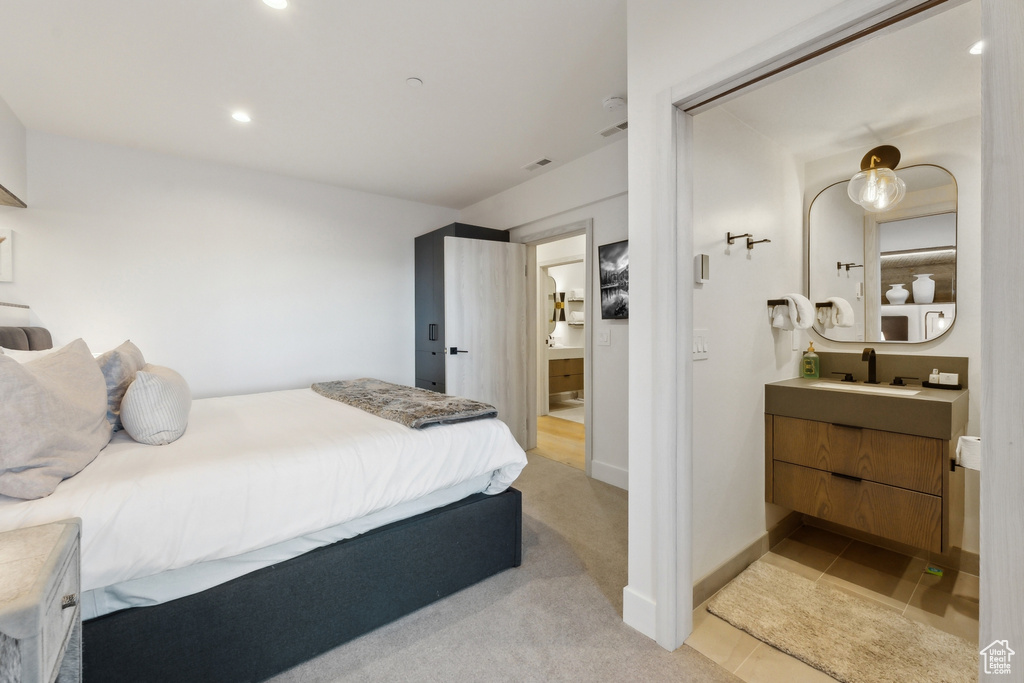 Bedroom featuring a sink, recessed lighting, ensuite bathroom, light colored carpet, and baseboards