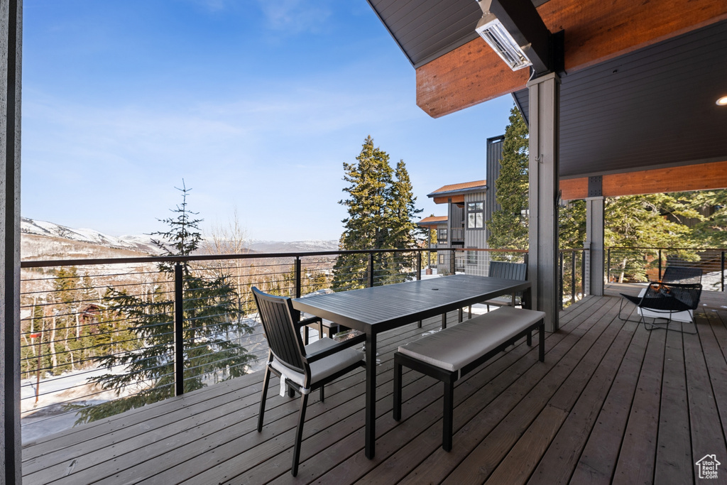 Wooden deck featuring outdoor dining space and a mountain view