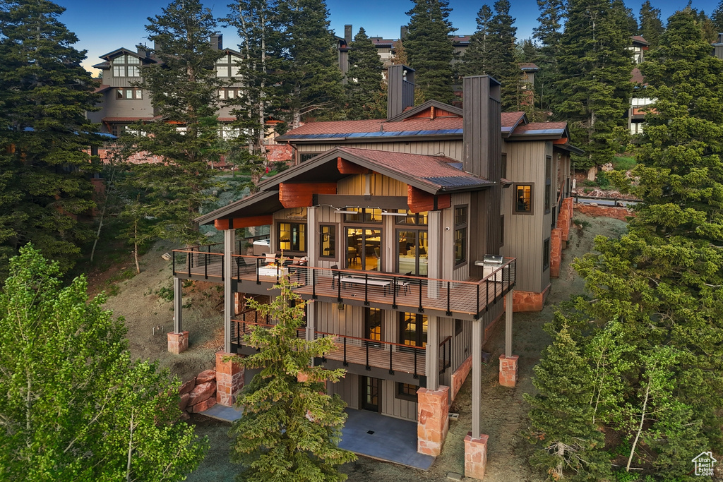 Rear view of house with a deck and a balcony
