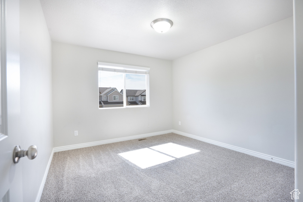 Empty room with carpet flooring and baseboards