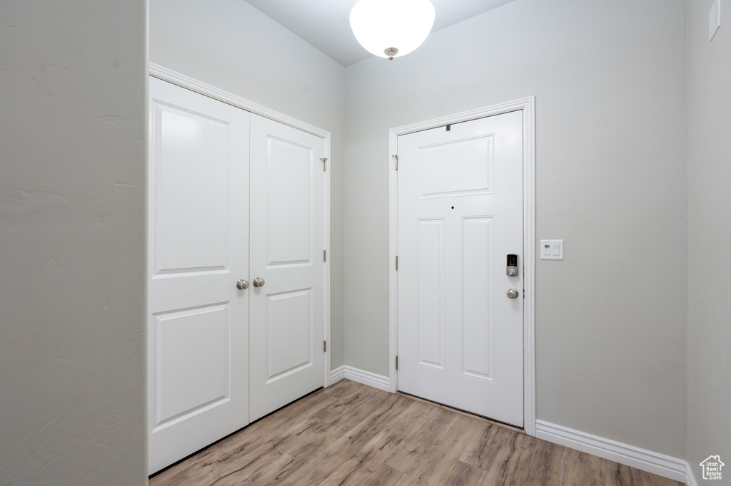 Foyer entrance with light wood-style floors and baseboards