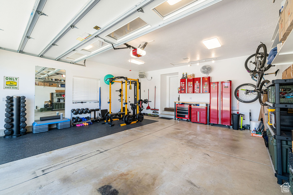 Garage featuring freestanding refrigerator and a garage door opener