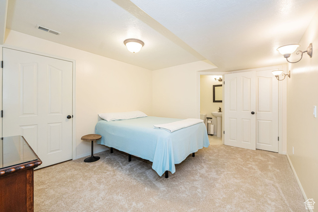 Bedroom featuring light carpet and baseboards