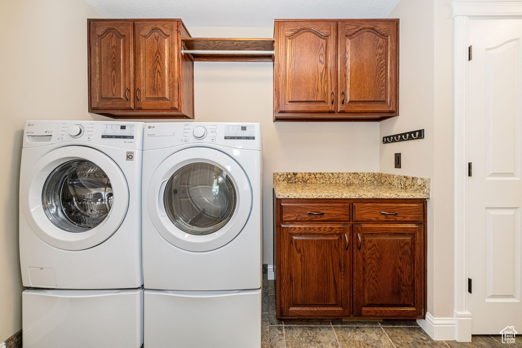 Washroom featuring cabinet space and washer and dryer