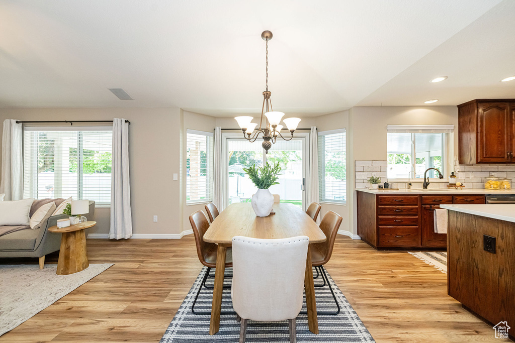 Dining room featuring a chandelier, light wood finished floors, baseboards, and recessed lighting