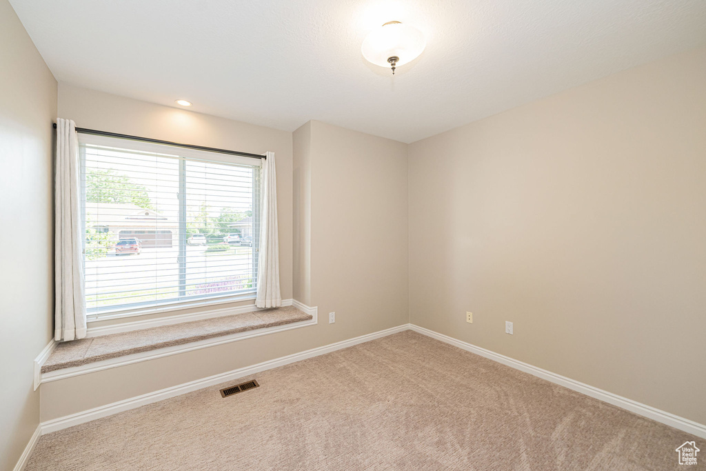 Empty room featuring carpet flooring and baseboards