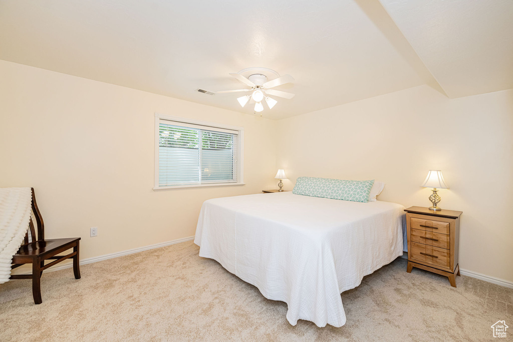 Bedroom featuring light colored carpet, baseboards, and a ceiling fan