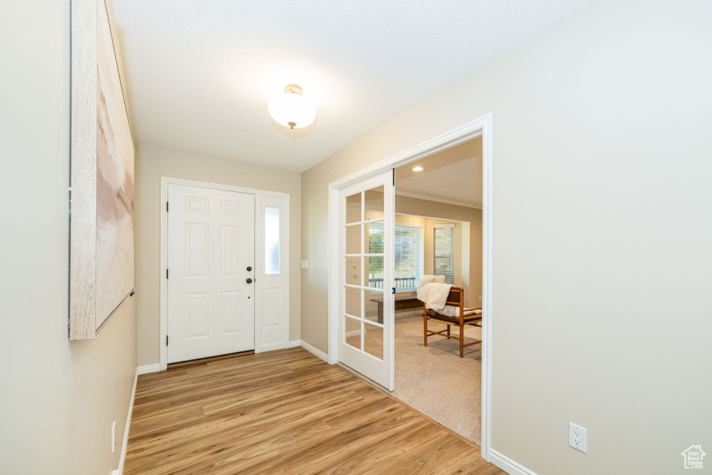 Entrance foyer featuring light wood finished floors, french doors, and baseboards