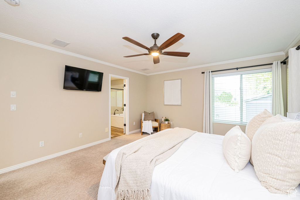 Bedroom with ornamental molding, baseboards, light carpet, ensuite bathroom, and ceiling fan