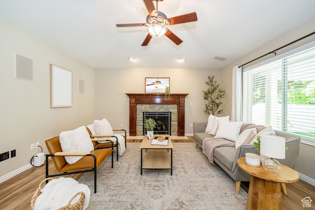Living area featuring light wood-style flooring, baseboards, healthy amount of natural light, and ceiling fan