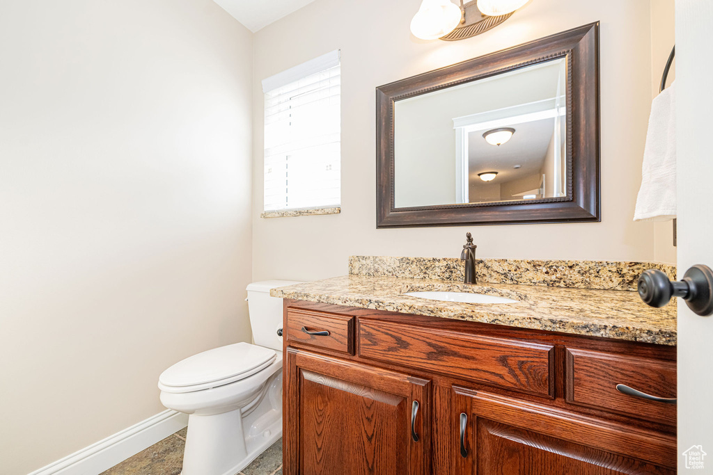 Bathroom with vanity, baseboards, and toilet
