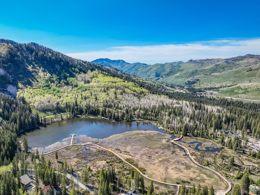 View of property location with a forest and a water and mountain view