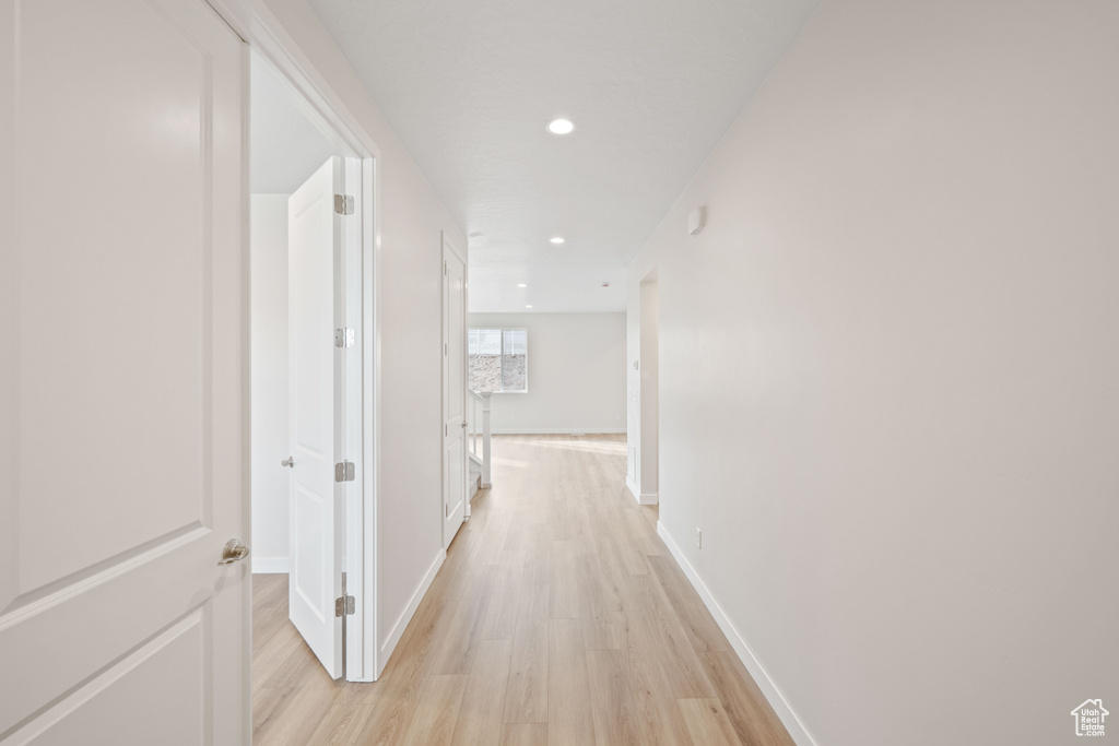 Hall with light wood-type flooring, recessed lighting, and baseboards