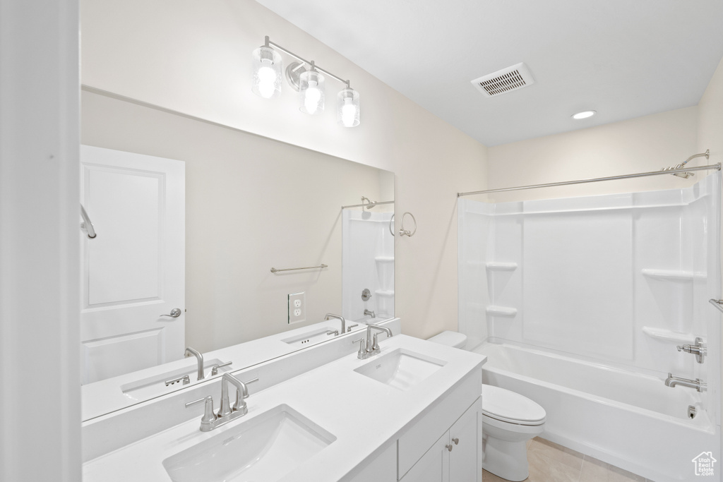 Bathroom featuring toilet,  shower combination, double vanity, and recessed lighting