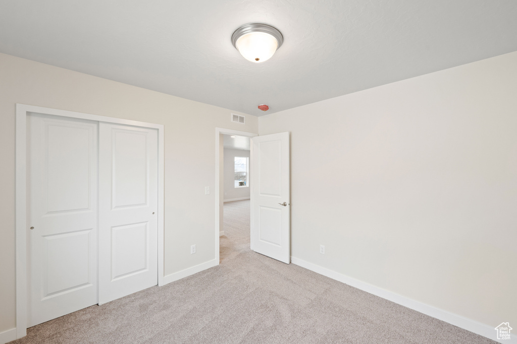 Unfurnished bedroom with carpet, baseboards, and a closet
