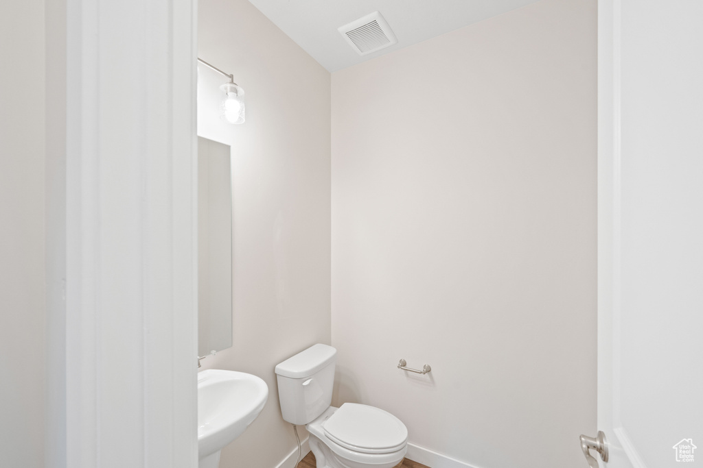 Half bath with a sink, toilet, and baseboards