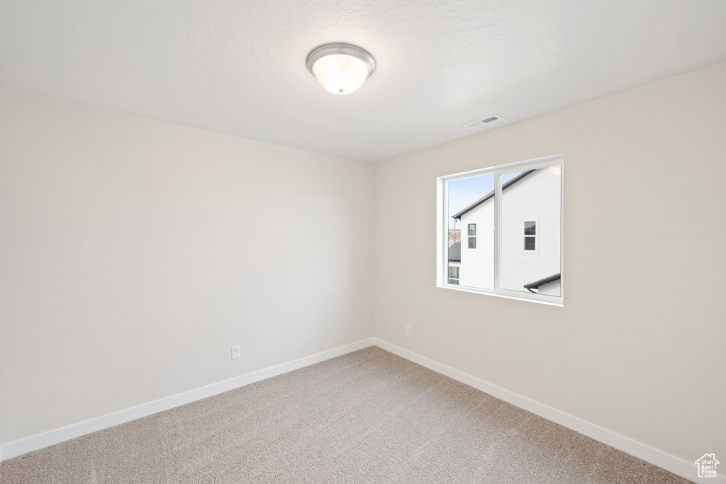 Spare room with light colored carpet and baseboards