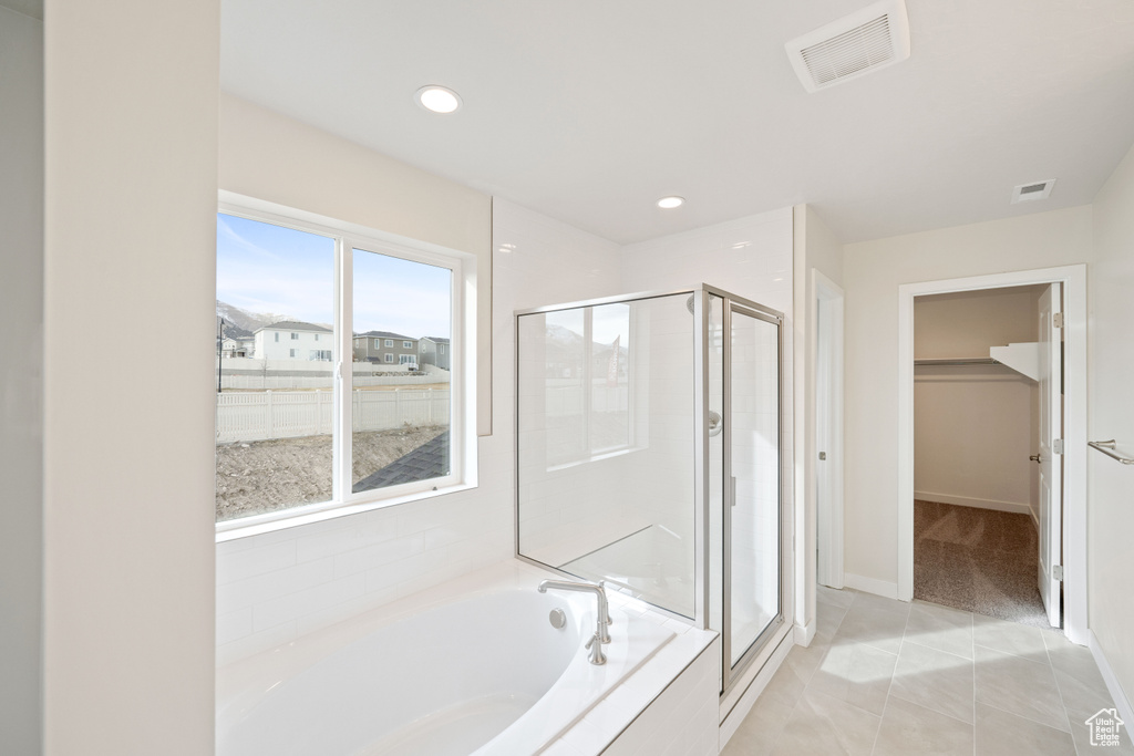 Full bath with a shower stall, a garden tub, a spacious closet, baseboards, and recessed lighting