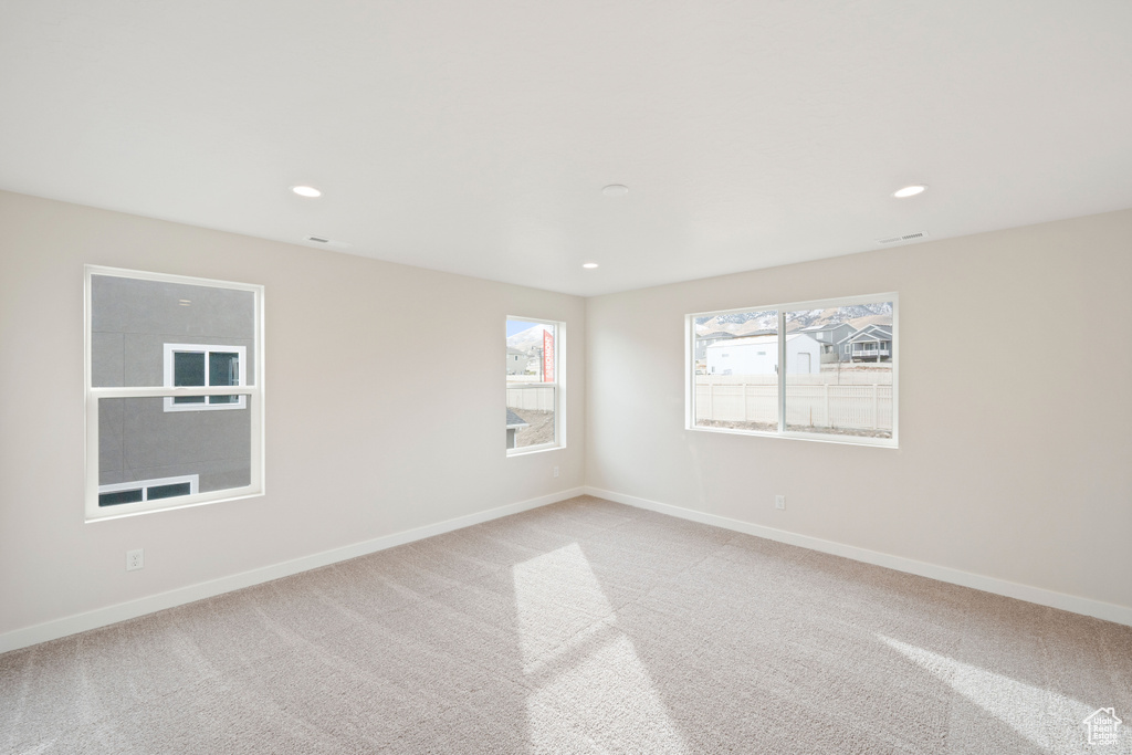 Unfurnished room with light colored carpet, recessed lighting, and baseboards