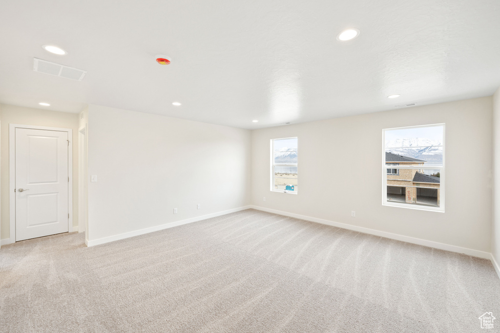 Unfurnished room featuring light carpet, recessed lighting, and baseboards