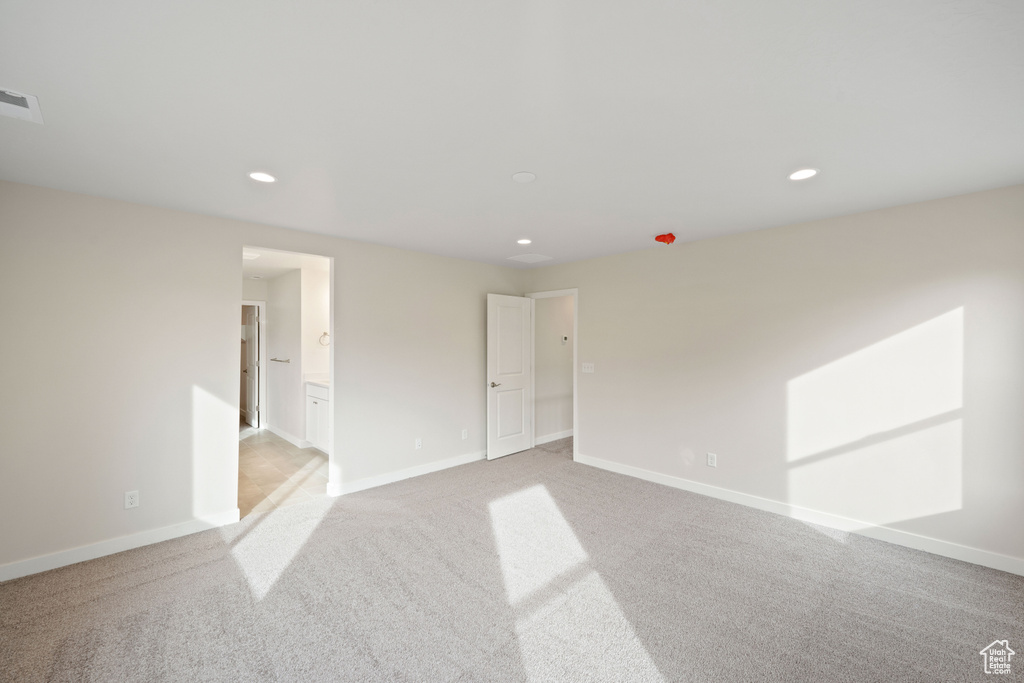 Spare room featuring light carpet, recessed lighting, and baseboards